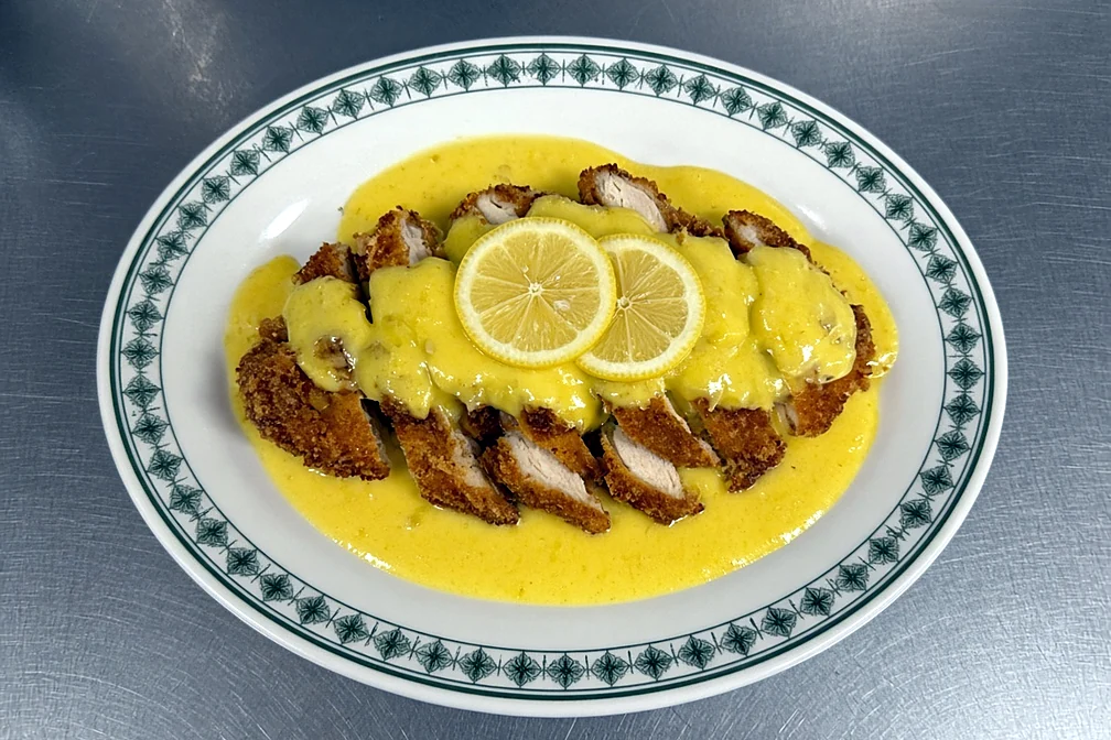 Breaded lemon chicken topped with lemon sauce and lemon slices