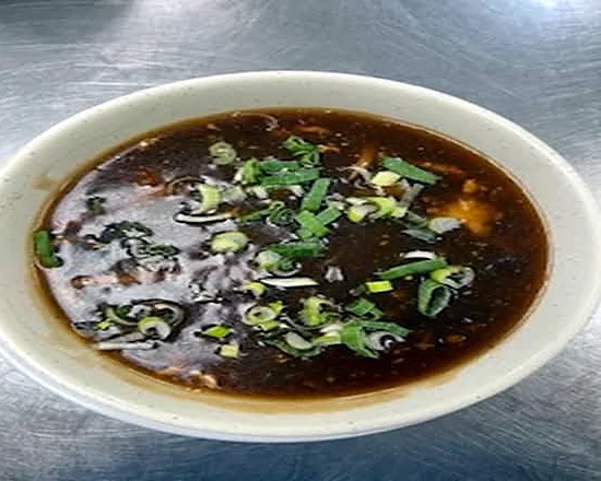 Hot and sour soup topped with green onion
